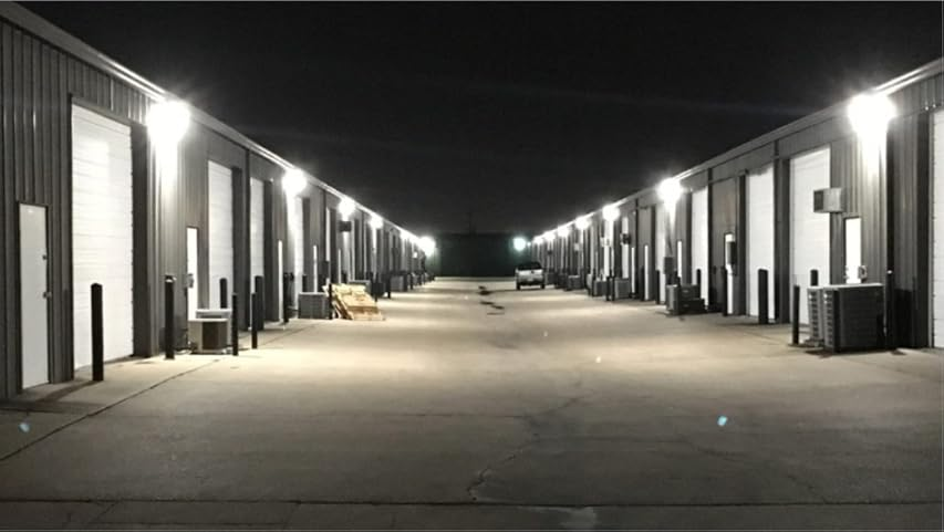 industrial buildings Wall Pack Lighting open garage doors at night.